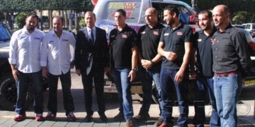 Foto de familia de los componentes de la escudería Grupo Raid, posando con el consejero de Deportes.