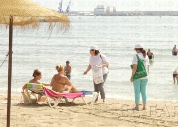 Voluntarias de la AECC reparten información para la prevención sobre la cáncer de piel entre los bañistas.