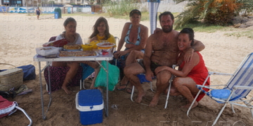 Una familia bajo una pérgola en la playa de San Lorenzo.