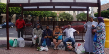 Los pasajeros, esperando en la parada de autobús la línea 6 para dirigirse a sus hogares.