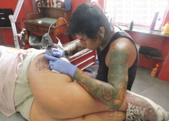 Pancho en su estudio, tatuando un mándala en el muslo de su clienta, Patricia.