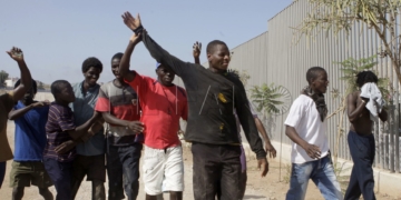 GRA237. MELILLA, 04/09/2016.- La última entrada de más de un centenar de inmigrantes subsaharianos en el salto a la valla que se ha producido hoy ha repuntado la ocupación del Centro de Estancia Temporal de Inmigrantes (CETI) de Melilla, que acoge en estos momentos a casi 900 personas, cifra cercana a su capacidad máxima. Según han informado fuentes de la Delegación del Gobierno en Melilla, antes del "salto masivo coordinado" que se ha producido a las 13.50 horas había 770 inmigrantes acogidos en el CETI, a los que hay que sumar los más de 100 que han accedido a la ciudad autónoma en este nuevo intento de entrada, el tercero en 15 días. En la foto, un grupo de inmigrantes que acaban de entrar gritan bozza (victoria). EFE/F.G Guerrero