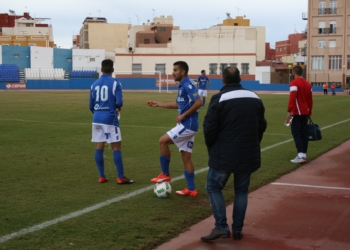 El técnico local, de espaldas, dando consignas a sus jugadores.