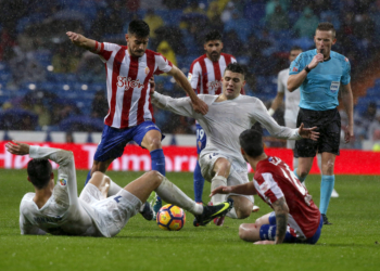El centrocampista croata del Real Madrid, Mateo Kovacic (d), disputa el balón ante el defensa del Sporting Sergio Álvarez (i).