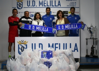 Foto de los capitanes y el técnico unionista, en el momento de hacer entrega  a Melillenses Solidarios en Acción.