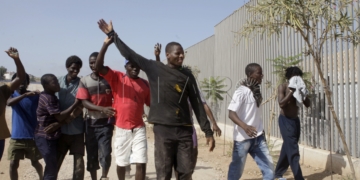 GRA237. MELILLA, 04/09/2016.- La última entrada de más de un centenar de inmigrantes subsaharianos en el salto a la valla que se ha producido hoy ha repuntado la ocupación del Centro de Estancia Temporal de Inmigrantes (CETI) de Melilla, que acoge en estos momentos a casi 900 personas, cifra cercana a su capacidad máxima. Según han informado fuentes de la Delegación del Gobierno en Melilla, antes del "salto masivo coordinado" que se ha producido a las 13.50 horas había 770 inmigrantes acogidos en el CETI, a los que hay que sumar los más de 100 que han accedido a la ciudad autónoma en este nuevo intento de entrada, el tercero en 15 días. En la foto, un grupo de inmigrantes que acaban de entrar gritan bozza (victoria). EFE/F.G Guerrero