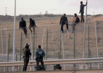 GRA003. MELILLA, 28/05/2014.- Unos 400 inmigrantes de origen subsahariano podrían haber accedido a la ciudad española de Melilla tras saltar hoy la valla fronteriza con Marruecos, lo que supondría una de las mayores entradas de inmigrantes a la ciudad. Tras saltar la valla, los subsaharianos se dirigieron corriendo hacia el Centro de Estancia Temporal de Inmigrantes (CETI), donde fueron recibidos por algunos de sus compatriotas con cánticos, abrazos y gritos de júbilo a las puertas del CETI, un centro absolutamente colapsado. En la imagen, algunos inmigrantes subidos a la valla. EFE/Noelia Ramos