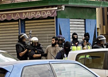 GRA028 MELILLA, 26/09/2014.- La Policía Nacional ha detenido hoy a nueve integrantes de una célula terrorista vinculada a la organización Estado Islámico y asentada en las ciudades de Melilla y Nador (Marruecos). En la imagen, agentes de la Policía junto a uno de los detenidos en el barrio de la Cañada de Hidum. EFE/F. G. Guerrero