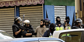 GRA028 MELILLA, 26/09/2014.- La Policía Nacional ha detenido hoy a nueve integrantes de una célula terrorista vinculada a la organización Estado Islámico y asentada en las ciudades de Melilla y Nador (Marruecos). En la imagen, agentes de la Policía junto a uno de los detenidos en el barrio de la Cañada de Hidum. EFE/F. G. Guerrero