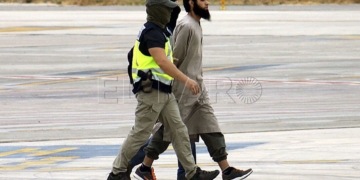GRA149 MELILLA, 26/09/2014.- El presunto líder de la célula terrorista vinculada al Estado Islámico (EI), detenido hoy en Melilla, custodiado por agentes de la Policía, a su llegada al aeropuerto de la ciudad autónoma desde donde ha sido trasladado a Madrid para su puesta a disposición del Juzgado Central de Instrucción número 3 de la Audiencia Nacional, que supervisa esta operación. EFE/NEUPIC/Fernando Gutiérrez