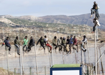 GRA039 MELILLA, 03/04/2014.- Unos 25 inmigrantes de origen subsahariano permanecen encaramados en la parte alta de la valla de Melilla y forman parte de un grupo que ha intentado acceder a la ciudad autónoma sobre las 09.00 horas. Los inmigrantes están en la zona de Aguadú, la parte más al norte del perímetro de Melilla. EFE/Neupic/Juan Ríos