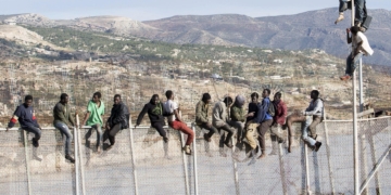 GRA039 MELILLA, 03/04/2014.- Unos 25 inmigrantes de origen subsahariano permanecen encaramados en la parte alta de la valla de Melilla y forman parte de un grupo que ha intentado acceder a la ciudad autónoma sobre las 09.00 horas. Los inmigrantes están en la zona de Aguadú, la parte más al norte del perímetro de Melilla. EFE/Neupic/Juan Ríos
