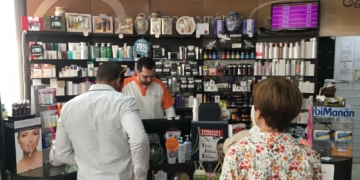 Un profesional de la farmacia Plaza España atendiendo a los clientes.