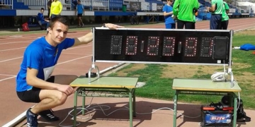 Francisco Galiano posa junto al tiempo que realizó en su prueba de 200 m.
