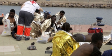 GRA332. MELILLA, 19/05/2017.- Un efectivo de la Cruz Roja atiende esta tarde a varios de los 24 inmigrantes de origen subsahariano después de que la patera con la que intentaban llegar a Melilla haya naufragado. El rescate se ha producido en las inmediaciones de Aguadú (al norte de Melilla), y los inmigrantes han sido trasladados al puerto deportivo en la embarcación del GEAS de la Guardia Civil. EFE/F.G.GUERRERO