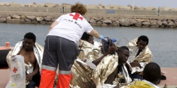 GRA332. MELILLA, 19/05/2017.- Un efectivo de la Cruz Roja atiende esta tarde a varios de los 24 inmigrantes de origen subsahariano después de que la patera con la que intentaban llegar a Melilla haya naufragado. El rescate se ha producido en las inmediaciones de Aguadú (al norte de Melilla), y los inmigrantes han sido trasladados al puerto deportivo en la embarcación del GEAS de la Guardia Civil. EFE/F.G.GUERRERO