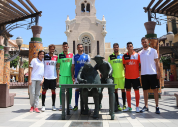 Varios jugadores y miembros del cuerpo técnico posan con las nuevas indumentarias en pleno centro de Melilla.