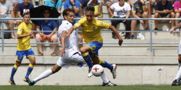 El centrocampista de la UD Melilla, Nando de la Rosa, en su intento de arrebatarle un balón a un jugador de Las Palmas Atlético