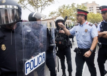 GRA279 L'HOSPITALET DE LLOBREGAT (BARCELONA), 20/09/2017.- Agentes antidisturbios de la Policía Nacional y de los Mossos d' Esquadra discuten frente al Instituto Can Vilumara de L'Hospitalet de Llobregat. Policía Nacional y Guardia Civil han desplegado a sus agentes en varios colegios electorales de Barcelona para impedir el referéndum del 1-O, suspendido por el Tribunal Constitucional (TC). EFE/Quique García