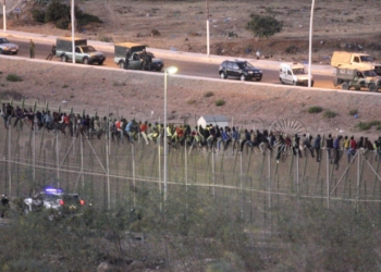 GRA001 MELILLA, 13/08/2014.- Cientos de inmigrantes de origen subsahariano protagonizan esta madrugada un nuevo intento de entrada masivo a Melilla, con al menos un centenar de ellos directamente encaramados a la valla fronteriza con Marruecos. EFE/Francisco G. Guerrero