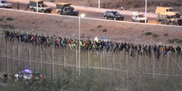 GRA001 MELILLA, 13/08/2014.- Cientos de inmigrantes de origen subsahariano protagonizan esta madrugada un nuevo intento de entrada masivo a Melilla, con al menos un centenar de ellos directamente encaramados a la valla fronteriza con Marruecos. EFE/Francisco G. Guerrero
