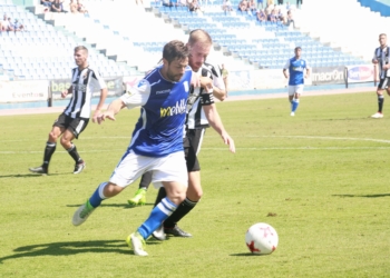 Pugna por en balón entre un jugador local y uno gaditano