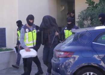 Agentes de la Policía Nacional sacan el pasado martes de la Jefatura de Melilla al detenido acusado de yihadismo.