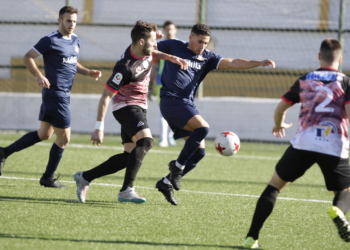 Uno de los jugadores melillenses, en plena lucha por el balón ante un futbolista del Loja CD.