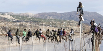 GRA039 MELILLA, 03/04/2014.- Unos 25 inmigrantes de origen subsahariano permanecen encaramados en la parte alta de la valla de Melilla y forman parte de un grupo que ha intentado acceder a la ciudad autónoma sobre las 09.00 horas. Los inmigrantes están en la zona de Aguadú, la parte más al norte del perímetro de Melilla. EFE/Neupic/Juan Ríos