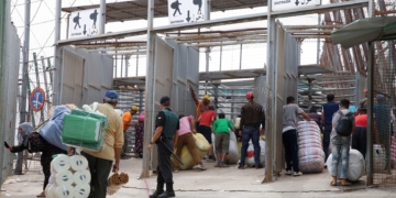 GRAF1091. MELILLA, 12/09/2018.- Varias personas en la frontera de Barrio Chino, en Melilla, que dedica la mitad del día a los porteadores y es la que más aumentó su tráfico el año pasado, al ser utilizada por 1.563.568 en ambos sentidos, un 11,56 % más que en 2016, lo que da una idea del auge del comercio atípico en los últimos tiempos en Melilla. Melilla, que tiene cuatro pasos fronterizos con Marruecos por los que cruzan cada año en ambos sentidos más de 20 millones de personas y casi cinco millones de vehículos, está en vilo por el futuro de su aduana comercial, cerrada desde hace 43 días por decisión unilateral del país vecino. EFE/ F.G. Guerrero