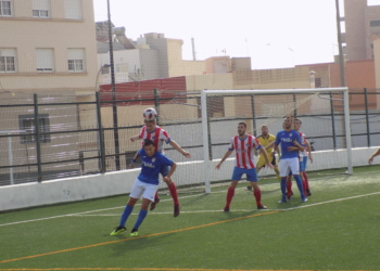 Lucha por un balón entre un jugador local y otro almeriense.