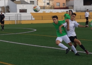 Lucha de un jugador de cada equipo por hacerse con el balón