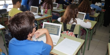 Niños en las aulas atendiendo al profesor.