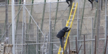 GRA122. MELILLA, 10/02/2015.- Varios de los inmigrantes encaramados a la valla de Melilla han decidido bajarse, tras permanecer en ella varias horas. Una decena de inmigrantes han permanecido encaramados en la valla de Melilla, en la zona del puesto fronterizo del Barrio Chino, donde hay un fuerte despliegue de la Guardia Civil, después de que un grupo de unos veinte subsaharianos haya conseguido acceder a la ciudad autónoma, en una noche en la que unas 400 personas, organizadas en grupos, han realizado varios conatos de salto en el perímetro fronterizo. EFE/Francisco Gª Guerrero