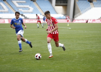 Un jugador de la UD Melilla, en su intento de robar el esférico a un rival.