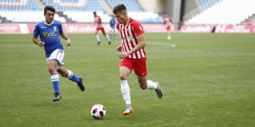 Un jugador de la UD Melilla, en su intento de robar el esférico a un rival.