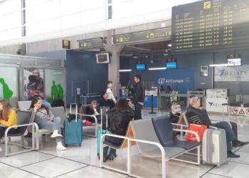 Pasajeros en el aeropuerto melillense, este viernes, tras ser informados de la cancelación del vuelo a Málaga.