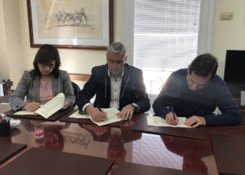 Los representantes y el consejero (en el centro), durante la firma.