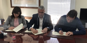 Los representantes y el consejero (en el centro), durante la firma.