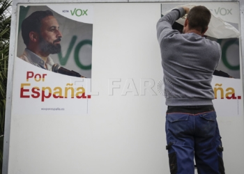 Un operario reubica el cartel situado en la plaza de España.