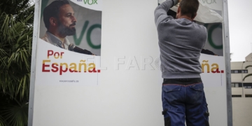 Un operario reubica el cartel situado en la plaza de España.