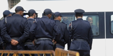RAB10. RABAT (MARRUECOS), 02/04/2015.- Policías marroquíes vigilan durante la salida de las furgonetas que trasladan a los trece detenidos el pasado mes de marzo en Marruecos por su supuesta pertenencia a una rama local del llamado Estado Islámico (Daesh por su acrónimo árabe), tras haber sido presentados ante el fiscal general del rey del Tribunal de Apelación de Salé, cerca de Rabat, Marruecos, el 2 de abril del 2015. EFE/Abdelhak Senna