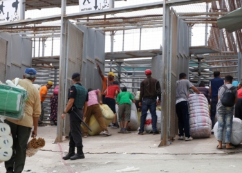 GRAF1091. MELILLA, 12/09/2018.- Varias personas en la frontera de Barrio Chino, en Melilla, que dedica la mitad del día a los porteadores y es la que más aumentó su tráfico el año pasado, al ser utilizada por 1.563.568 en ambos sentidos, un 11,56 % más que en 2016, lo que da una idea del auge del comercio atípico en los últimos tiempos en Melilla. Melilla, que tiene cuatro pasos fronterizos con Marruecos por los que cruzan cada año en ambos sentidos más de 20 millones de personas y casi cinco millones de vehículos, está en vilo por el futuro de su aduana comercial, cerrada desde hace 43 días por decisión unilateral del país vecino. EFE/ F.G. Guerrero
