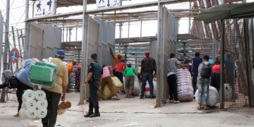 GRAF1091. MELILLA, 12/09/2018.- Varias personas en la frontera de Barrio Chino, en Melilla, que dedica la mitad del día a los porteadores y es la que más aumentó su tráfico el año pasado, al ser utilizada por 1.563.568 en ambos sentidos, un 11,56 % más que en 2016, lo que da una idea del auge del comercio atípico en los últimos tiempos en Melilla. Melilla, que tiene cuatro pasos fronterizos con Marruecos por los que cruzan cada año en ambos sentidos más de 20 millones de personas y casi cinco millones de vehículos, está en vilo por el futuro de su aduana comercial, cerrada desde hace 43 días por decisión unilateral del país vecino. EFE/ F.G. Guerrero