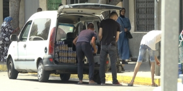 Imagen de un grupo de jóvenes descargando una furgoneta de mercancía.