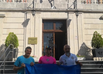 Tres de los componentes de la expedición local en tierras vitorianas con la bandera de Melilla.