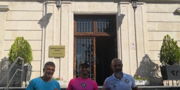 Tres de los componentes de la expedición local en tierras vitorianas con la bandera de Melilla.