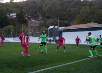 Héctor Gómez controla el balón entre dos jugadores rivales.