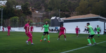 Héctor Gómez controla el balón entre dos jugadores rivales.