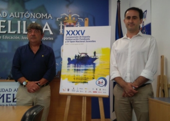 Víctor Fernández, presidente de la Federación Melillense de Pesca y Casting posa junto al viceconsejero de Deportes, Jalid Said, y el cartel anunciador del Campeonato de España.